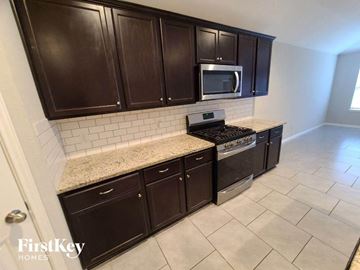 Katy house for rent - a kitchen with black cabinets and a counter top
