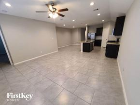 Katy house for rent - a large living room with tile flooring and a ceiling fan