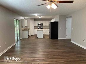 Jacksonville house for rent - a living room with a kitchen and a ceiling fan