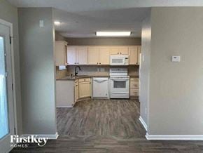 Charlotte house for rent - an empty kitchen with white appliances and wooden floors