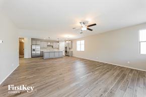 Surprise house for rent - A spacious room with wooden flooring and a ceiling fan.