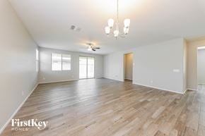 Surprise house for rent - A spacious room with wooden flooring and a chandelier.