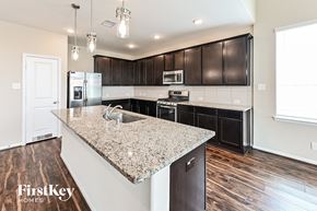 Baytown house for rent - a kitchen with dark wood cabinets and a granite counter top