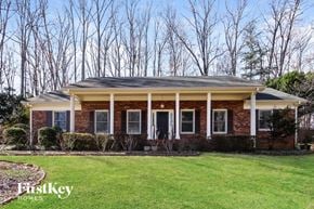 Lewisville house for rent - A brick house with a porch and a sign that says "FirstKey Homes".
