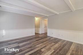 Lewisville house for rent - A room with wooden flooring and white walls, with a doorway leading to another room.