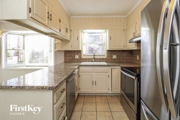 Lewisville house for rent - A kitchen with a granite countertop and stainless steel appliances.