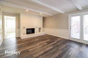 Lewisville house for rent - A spacious living room with a fireplace and wooden flooring.