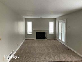 Reynoldsburg house for rent - a large empty living room with a fireplace