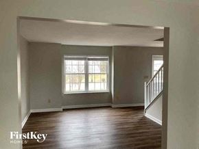Reynoldsburg house for rent - an empty living room with wood floors and a window