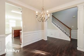 Lexington house for rent - an empty dining room with a staircase and a chandelier