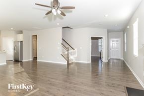 Wake Forest house for rent - A spacious living room with a staircase and a ceiling fan.