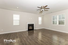 Wake Forest house for rent - A spacious room with a fireplace and a ceiling fan.