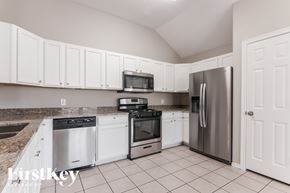 Joshua house for rent - A kitchen with white cabinets and appliances.