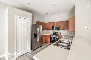 Seffner house for rent - a kitchen with stainless steel appliances and wooden cabinets