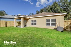 Seffner house for rent - a backyard with a house and a grass lawn