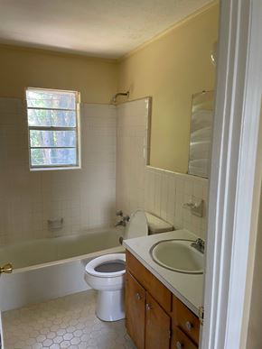 Forsyth apartment for rent - A white toilet sits in a bathroom with a white sink and a bathtub.