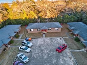 Macon apartment for rent - A parking lot with several cars and a building in the background.