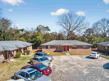 Macon apartment for rent - A parking lot with several cars and a building in the background.