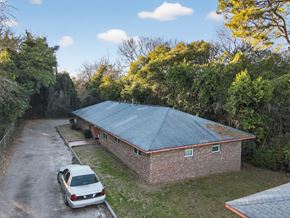Macon apartment for rent - A car is parked in front of a house with a metal roof.