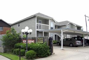 Tulsa apartment for rent - A two-story building with a balcony and a sign that says "Maple Park".