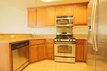 San Jose house for rent - a kitchen with stainless steel appliances and wooden cabinets