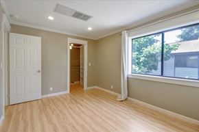 San Jose house for rent - A room with a white door and a window with a view of a house across the street.