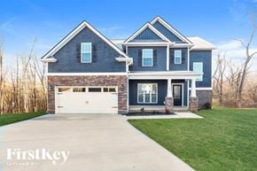 Clarksville house for rent - A blue house with a white garage door and a stone wall.