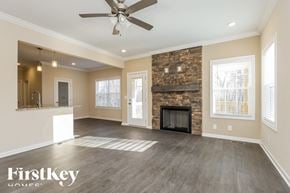 Clarksville house for rent - A spacious living room with a fireplace and a ceiling fan.