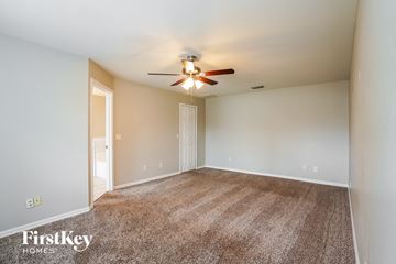 Cape Coral house for rent - a spacious living room with carpet and a ceiling fan