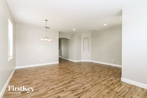 Cape Coral house for rent - A large empty room with wooden floors and a chandelier.