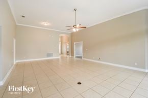 Fleming Island house for rent - A spacious room with a ceiling fan and tiled flooring.