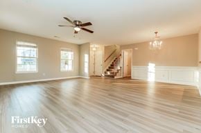 Summerville house for rent - A spacious room with wooden floors and a ceiling fan.