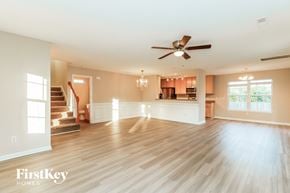 Summerville house for rent - A spacious living room with wooden floors and a ceiling fan.