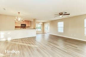 Summerville house for rent - A spacious living room with wooden floors and a ceiling fan.