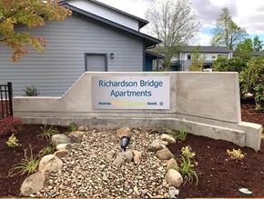 Eugene apartment for rent - a retaining wall with a sign in front of a building