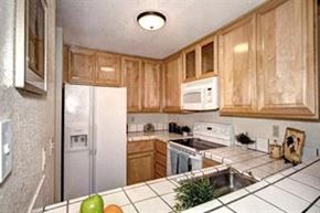 San Jose house for rent - a kitchen with wooden cabinets and a refrigerator