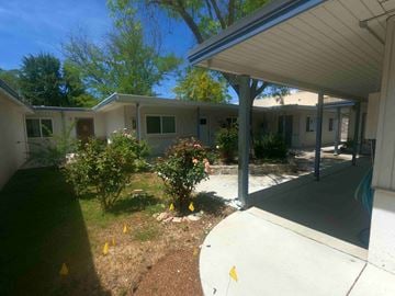 Davis apartment for rent - A building with a white roof and a small garden in front.