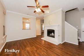 Fort Worth house for rent - A spacious living room with a fireplace and a ceiling fan.
