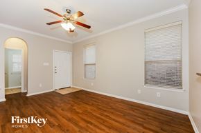 Fort Worth house for rent - A room with a ceiling fan and wooden floors.
