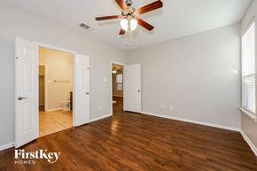 Fort Worth house for rent - A spacious room with a ceiling fan and wooden flooring.