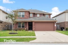Rosharon house for rent - a house with a driveway and a garage door