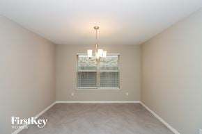 Rosharon house for rent - a empty dining room with a window and a chandelier