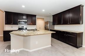 Rosharon house for rent - a kitchen with black cabinets and a counter top