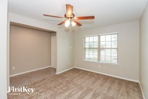 Rosharon house for rent - a bedroom with a ceiling fan and a window