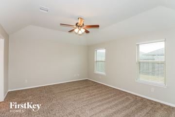 Rosharon house for rent - a living room with a ceiling fan and a carpet