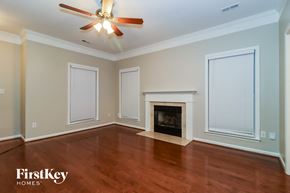 Huntersville house for rent - A room with a fireplace and a ceiling fan.