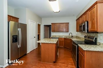 Huntersville house for rent - A kitchen with wooden cabinets and a granite countertop.