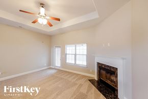 Montevallo house for rent - A spacious room with a fireplace and a ceiling fan.