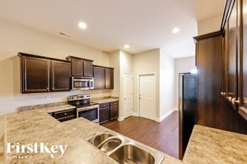 Montevallo house for rent - A kitchen with dark wood cabinets and a stainless steel sink.