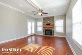 Clarksville house for rent - A spacious room with a fireplace and a ceiling fan.